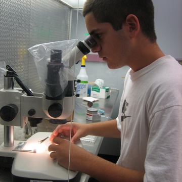 High school intern Oscar working in the lab